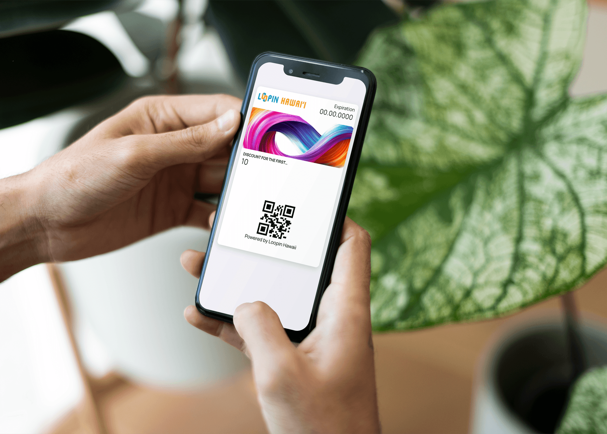 Hand holding a phone with a digital loyalty card in Apple Wallet
